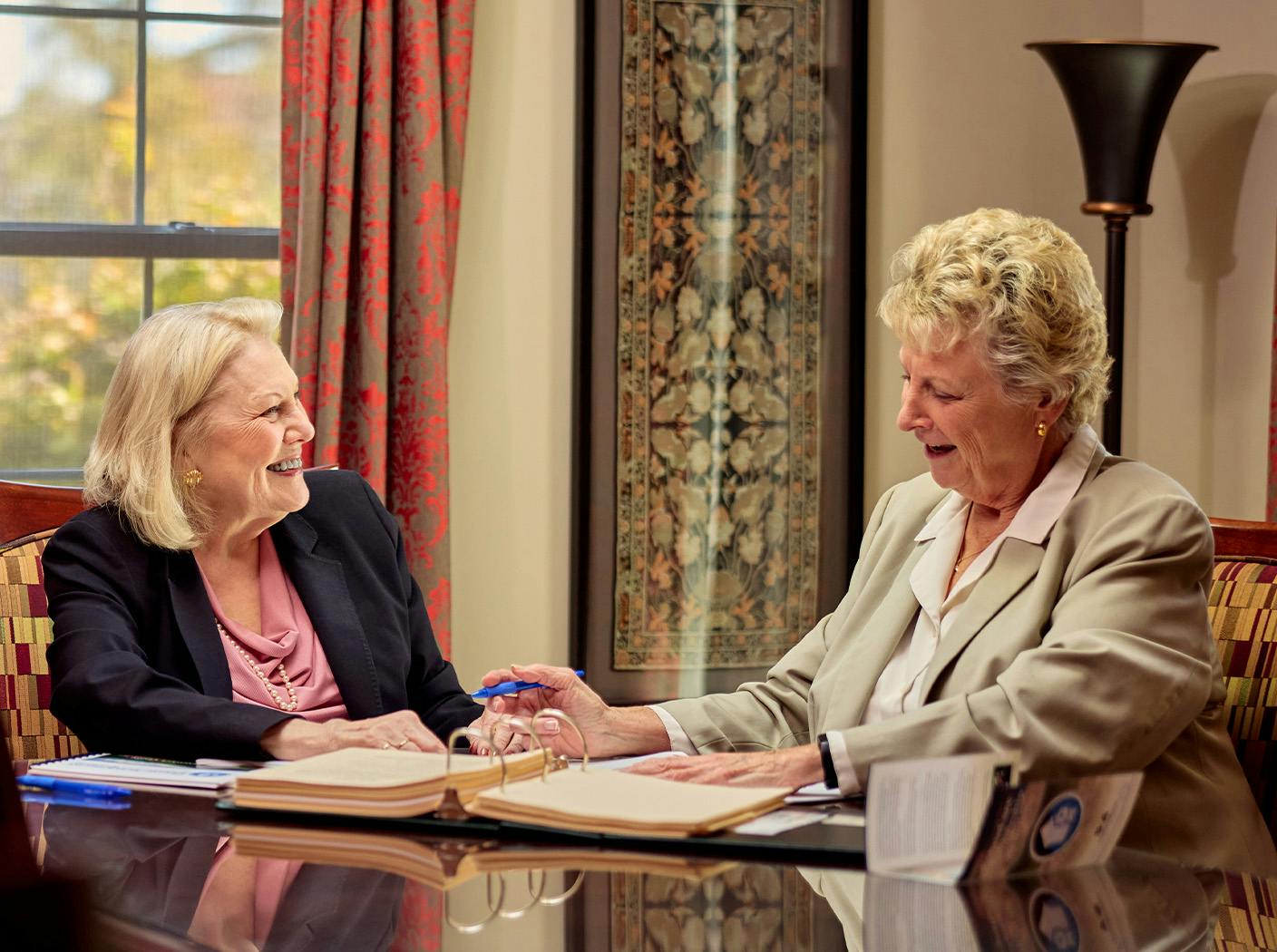 female attorney smiling at her client as client lookings at documents