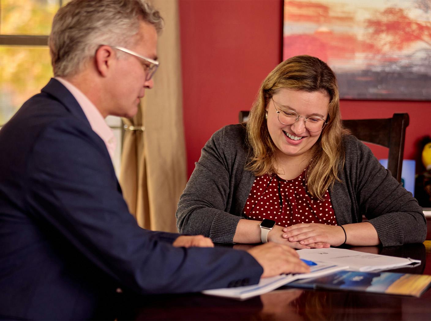 woman smiling with attorney as they looking at paperwork