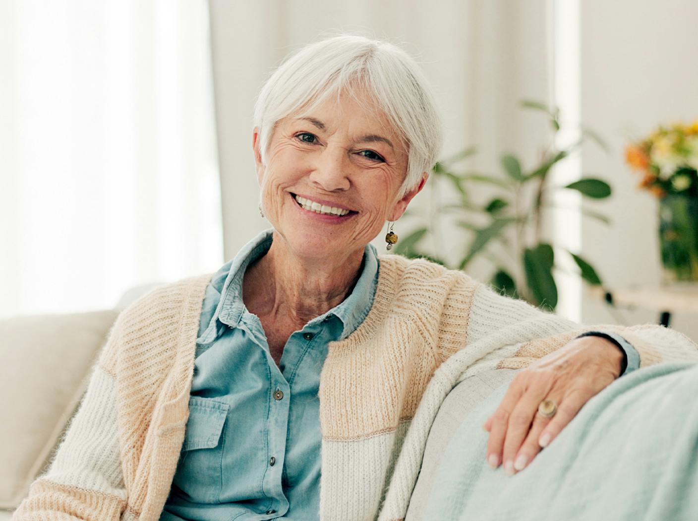older woman smiling while sitting on couch