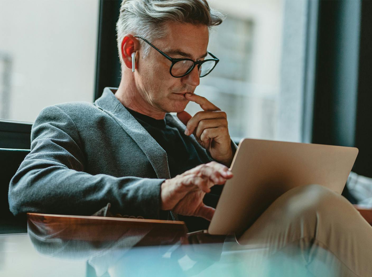 man with airpod looking at laptop