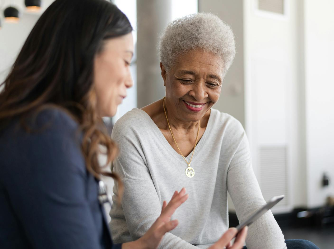 woman showing her phone to older woman