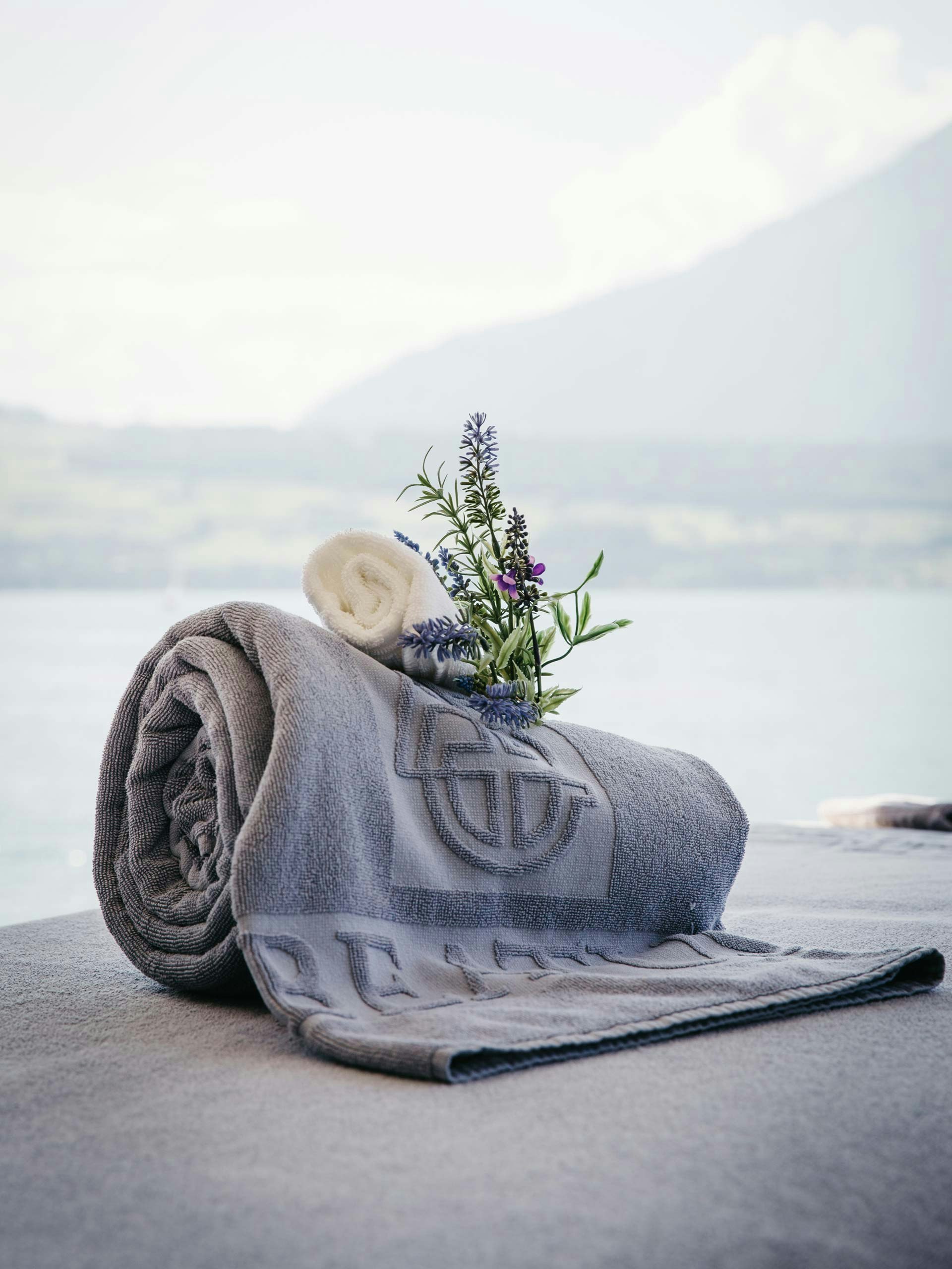 Massage by the lake at Hotel BEATUS Bath towel with herbal bouquet on massage table in front of the lake
