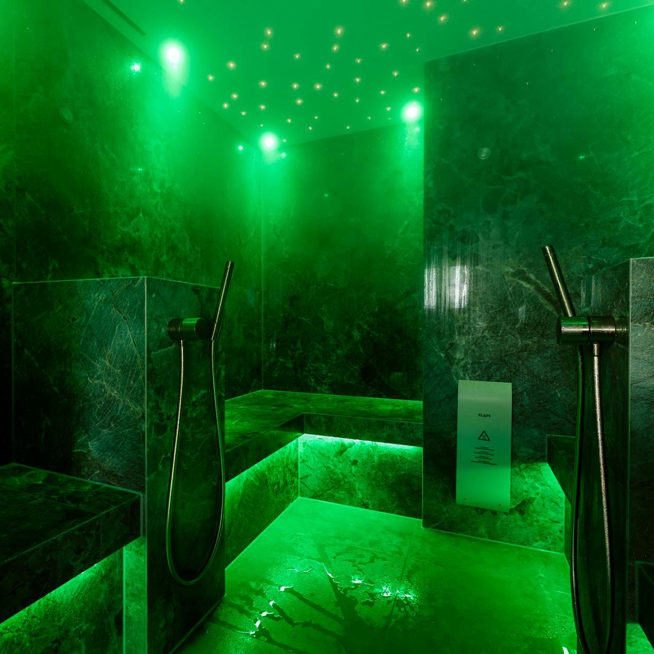 Bain de vapeur à l'hôtel BEATUS Bain de vapeur en marbre éclairé en vert vif avec deux tuyaux de douche