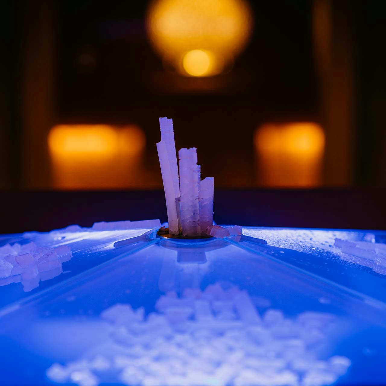 Fontaine de glace en stalagmite dans le sauna classique de l'hôtel BEATUS Pics de glace éclairés en rouge et bleu qui poussent vers le haut