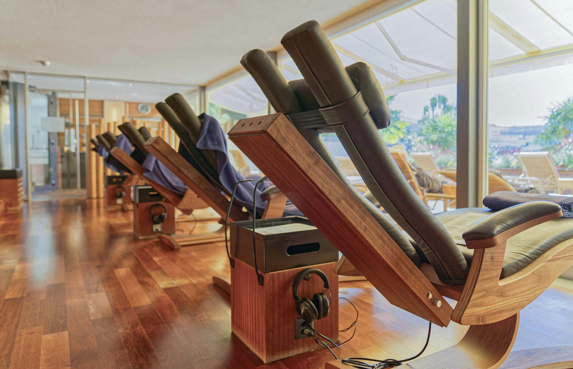 Leather and wooden loungers with a view to the outside, next to a loudspeaker with headphones,