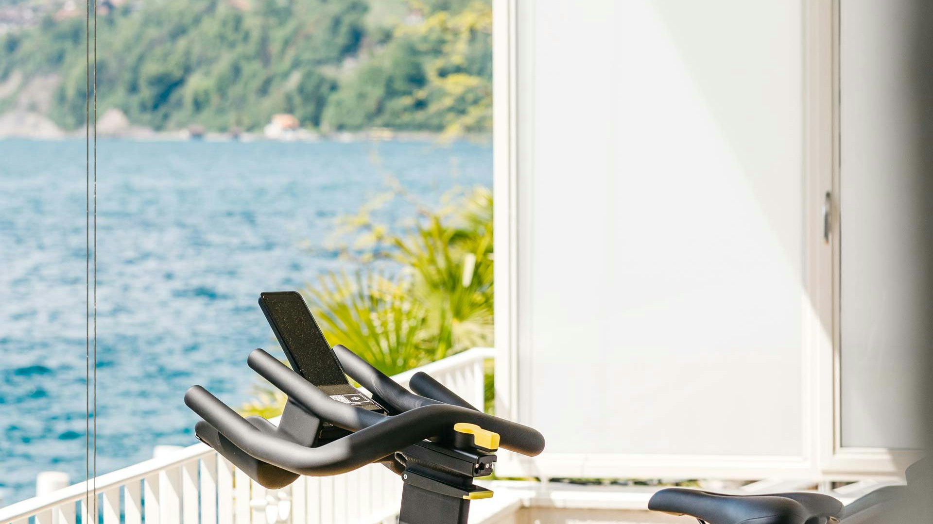 Fitness-Balkon im Hotel BEATUS Gelbes Fitnessfahrrad auf Balkon mit Blick auf den Thunersee