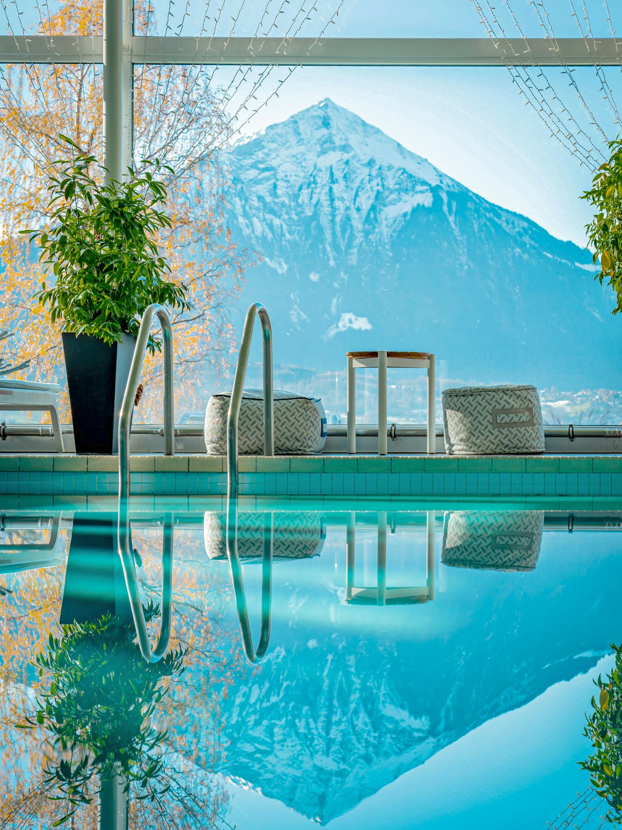 View of the Niesen from the indoor pool of the Hotel BEATUS In front you can only see water from the indoor pool, reflecting the mountain you can see behind the window