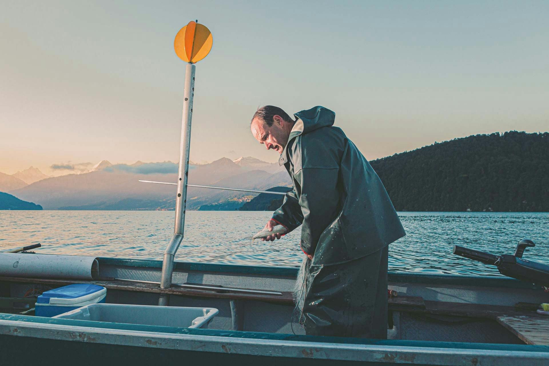 Fisherman in oilskins on a boat on Lake Thun