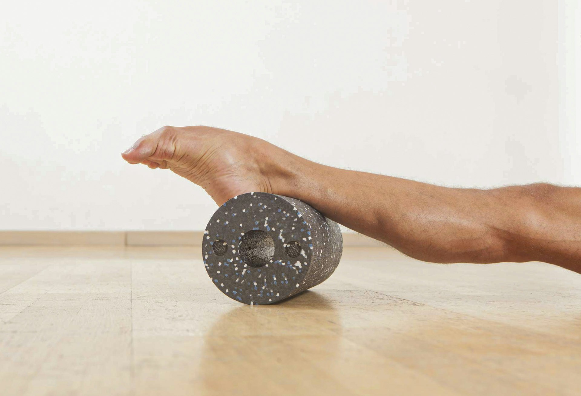 Stretched leg and foot on a dark plastic roller