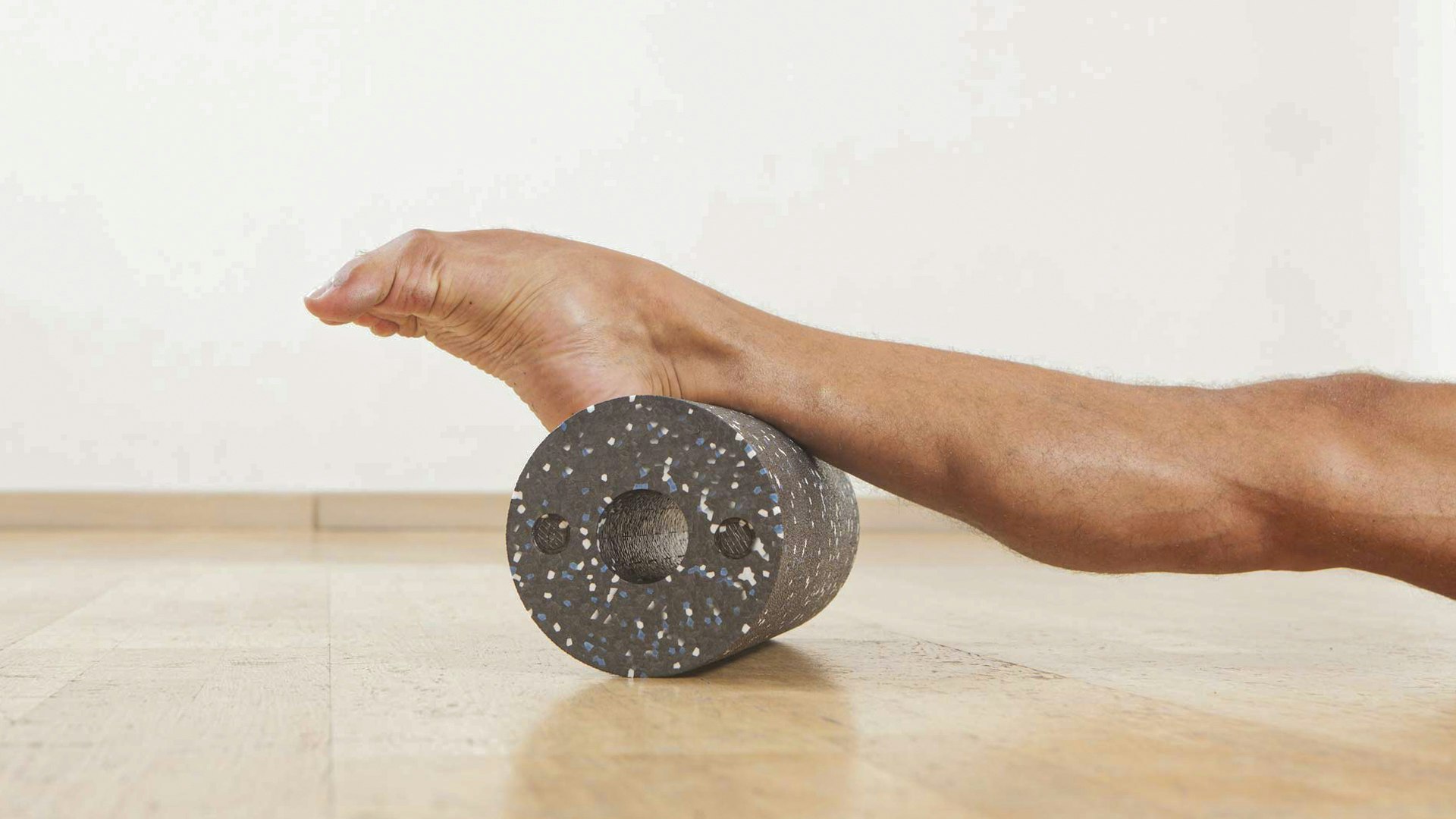 Blackroll Stretched leg and foot on a dark plastic roller