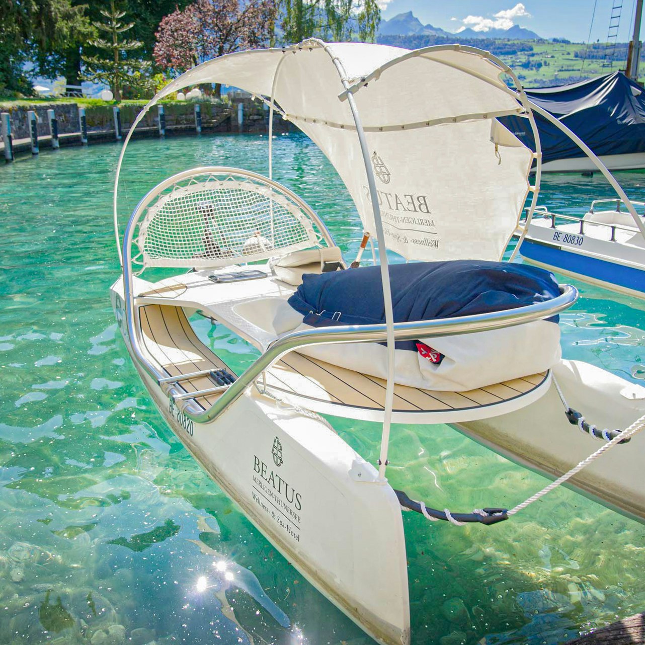 Wassersport im Hotel BEATUS Ein kleines Katamaran mit Sonnensegel liegt in einem Hafen