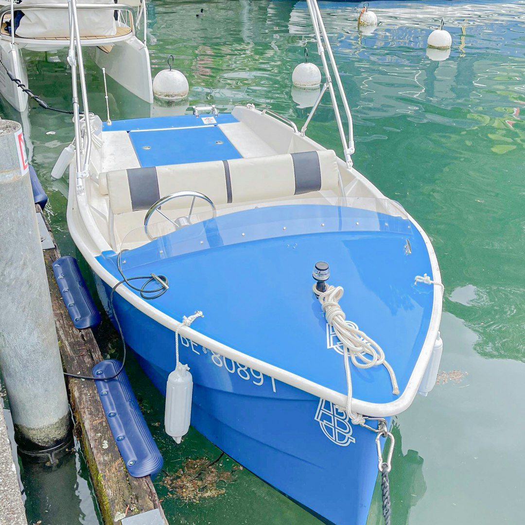 Wassersport im Hotel Beatus Ein kleines Boot liegt am Hafen, dahinter ein Ausflugsboot