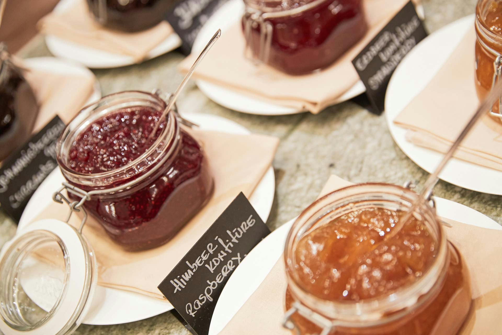 Breakfast buffet with different types of jam in a jar with spoon
