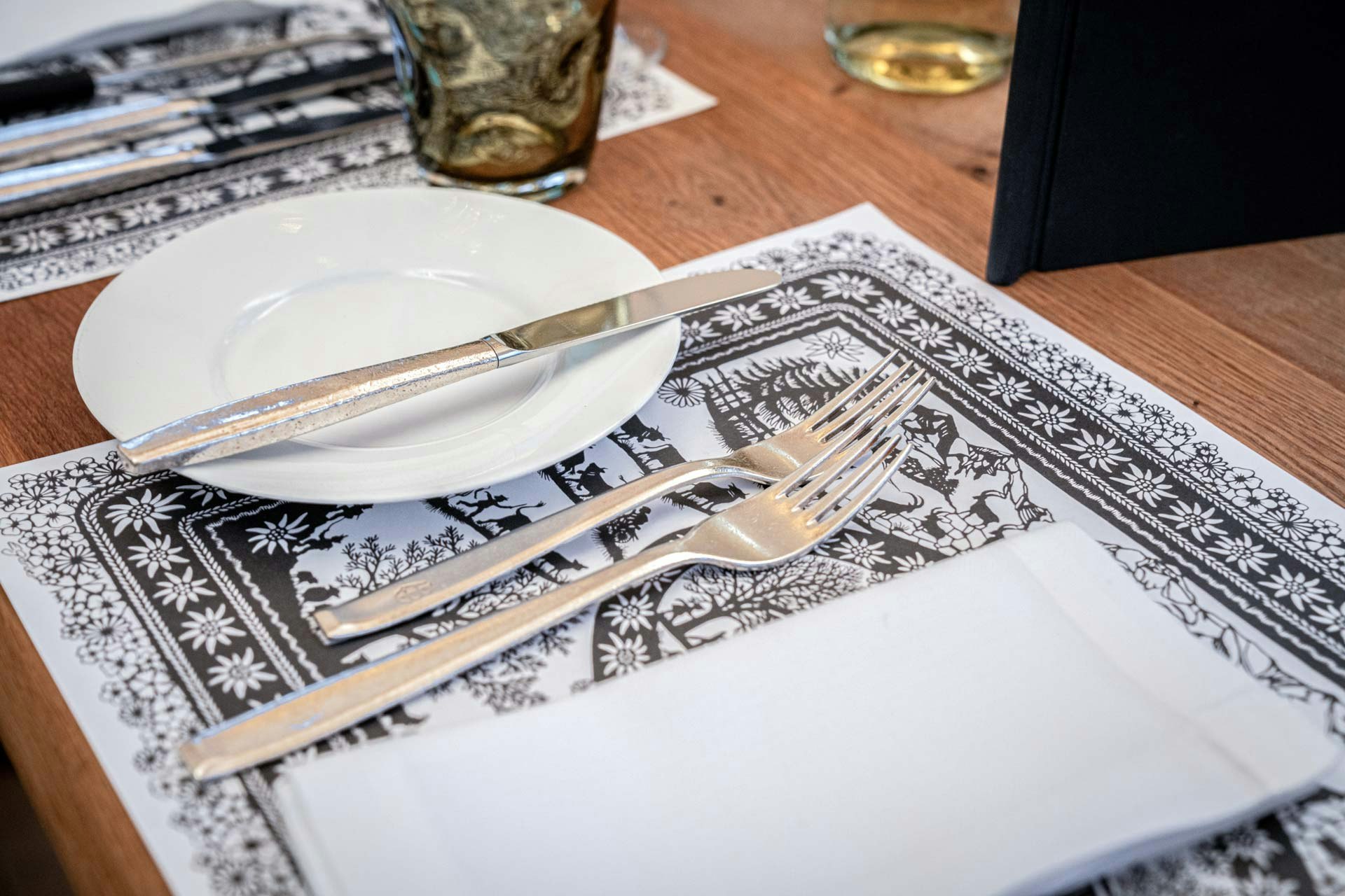 Black and white placemat with silhouette motif, napkin, plate and cutlery