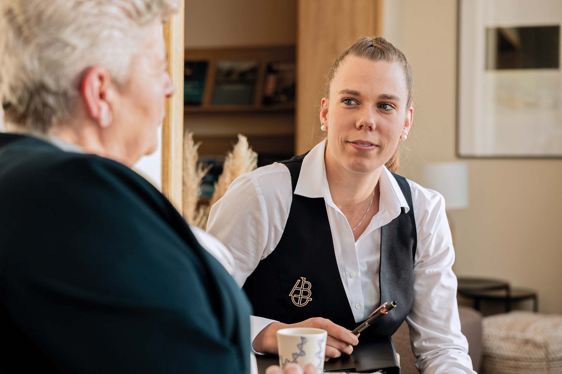 Friendly woman with white shirt and black gilet in customer contact