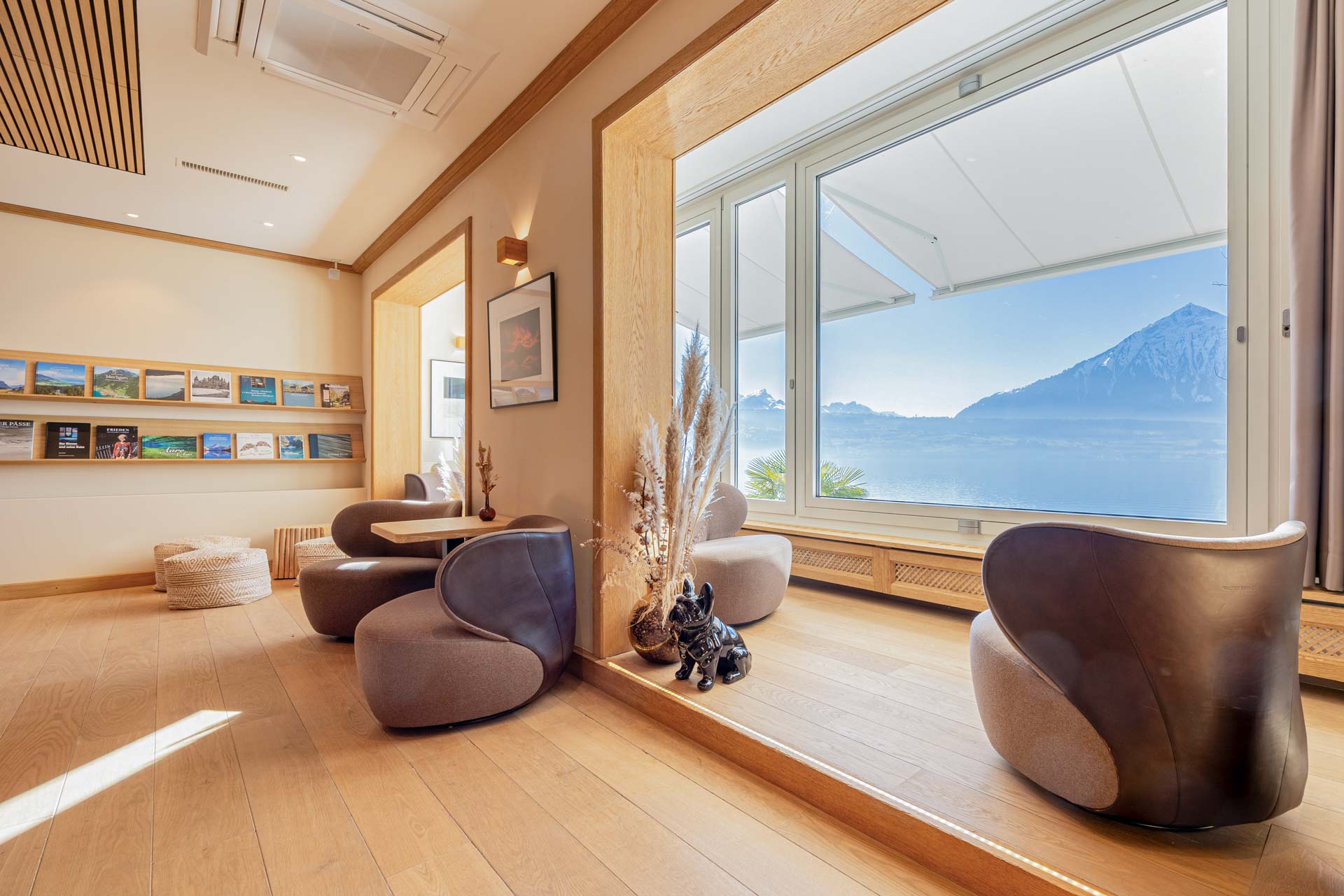 Gemütliche Polstermöbel, Holzboden, grosses Panoramafenster mit Seeblick