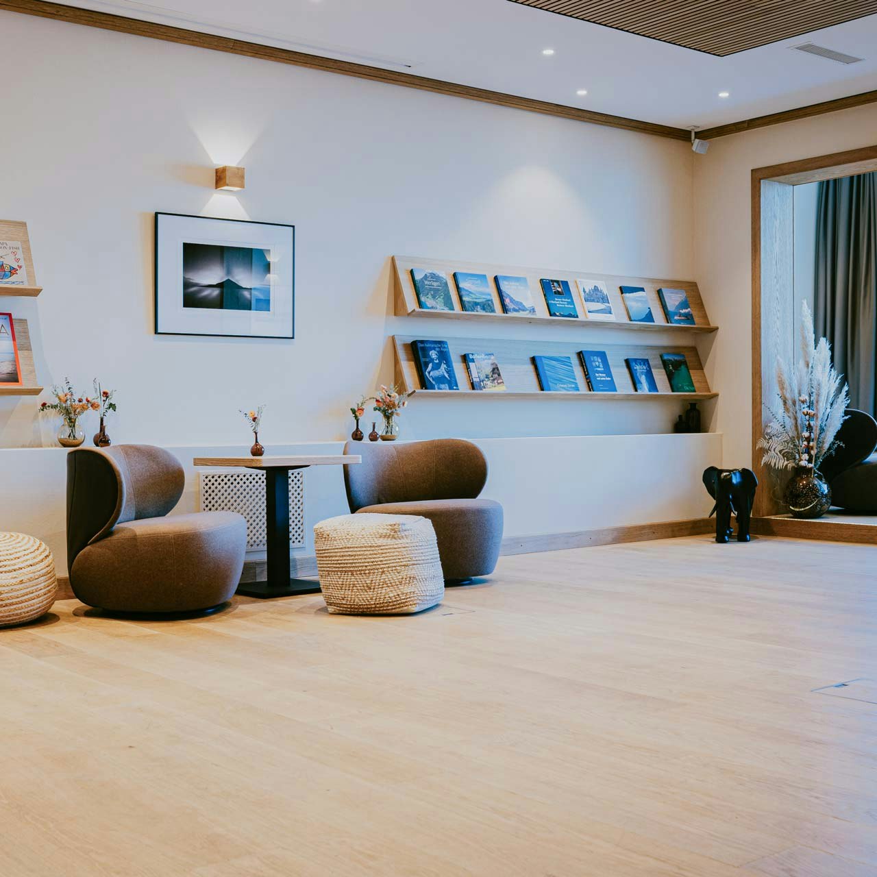 Salle de séminaire à l'hôtel BEATUS Pièce vide, meubles rembourrés et petites tables sur les côtés, étagère avec des magazines, grande fenêtre
