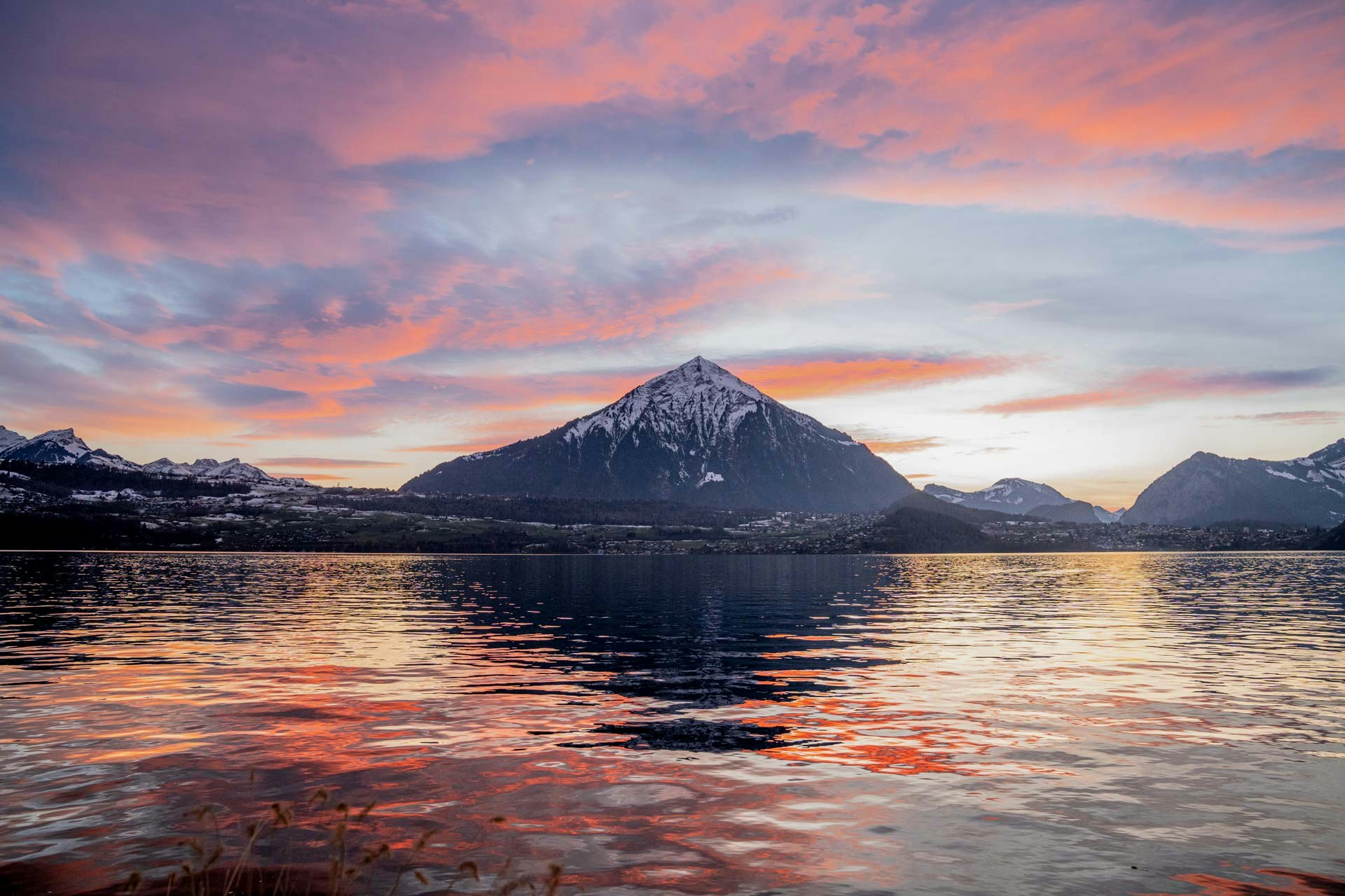 Vorne der See, hinten der Niesen und alles im orange-blauen Dämmerlicht