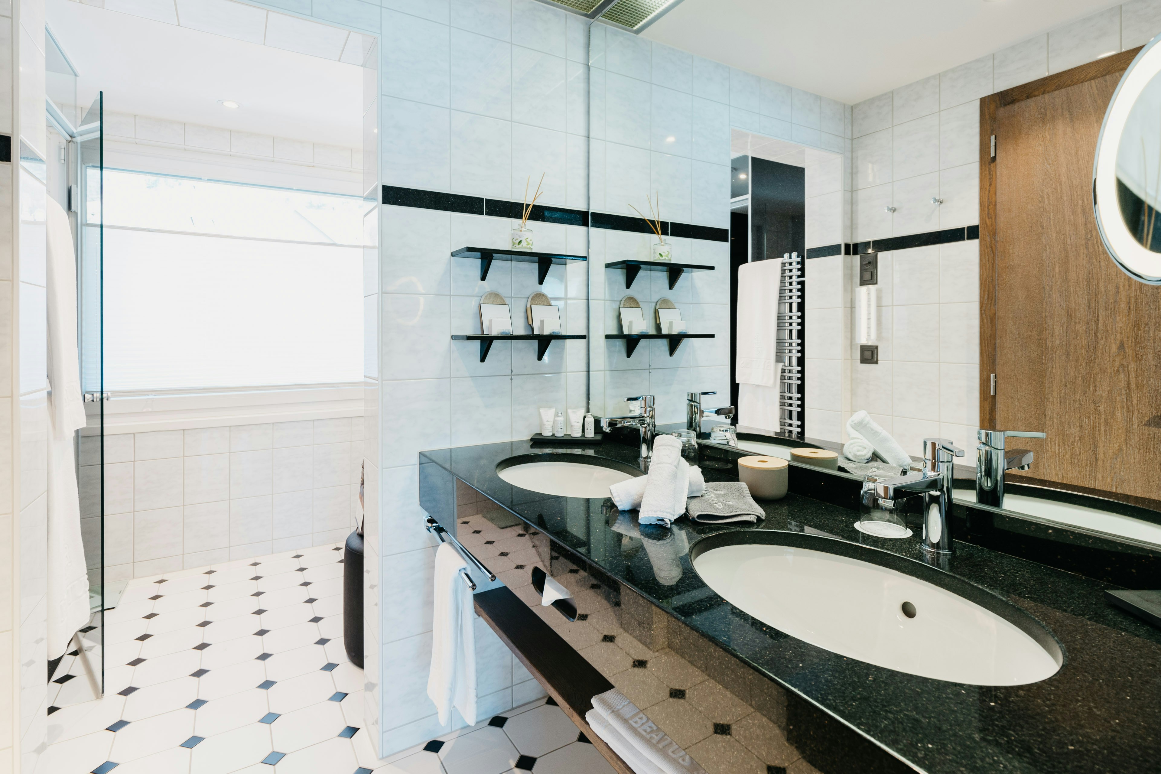 Badezimmer in schwarz-weiss mit grossem Fenster, Spiegel, zwei Waschbecken