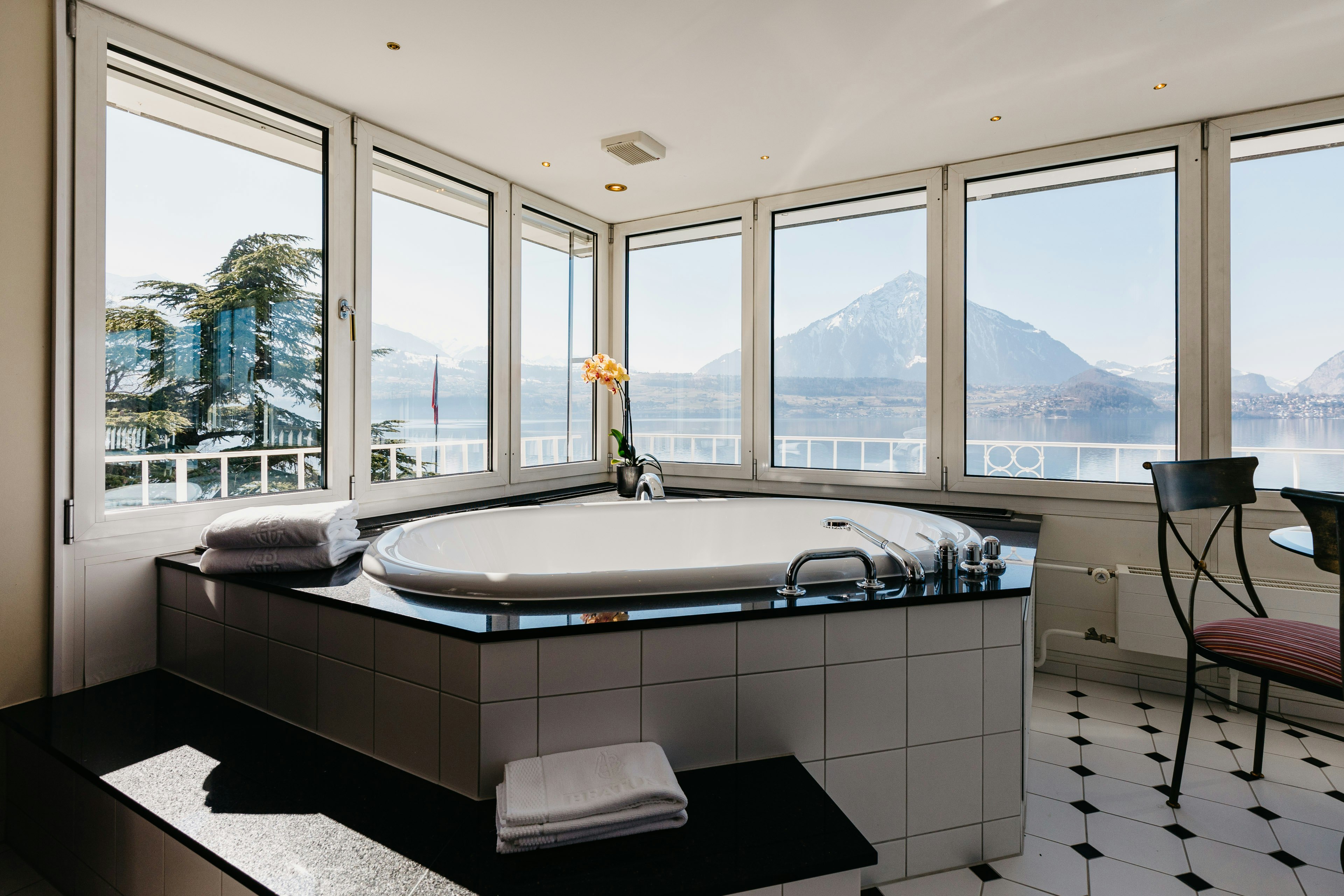 Whirlwanne umgeben von Panoramafenstern mit Blick auf die Berge