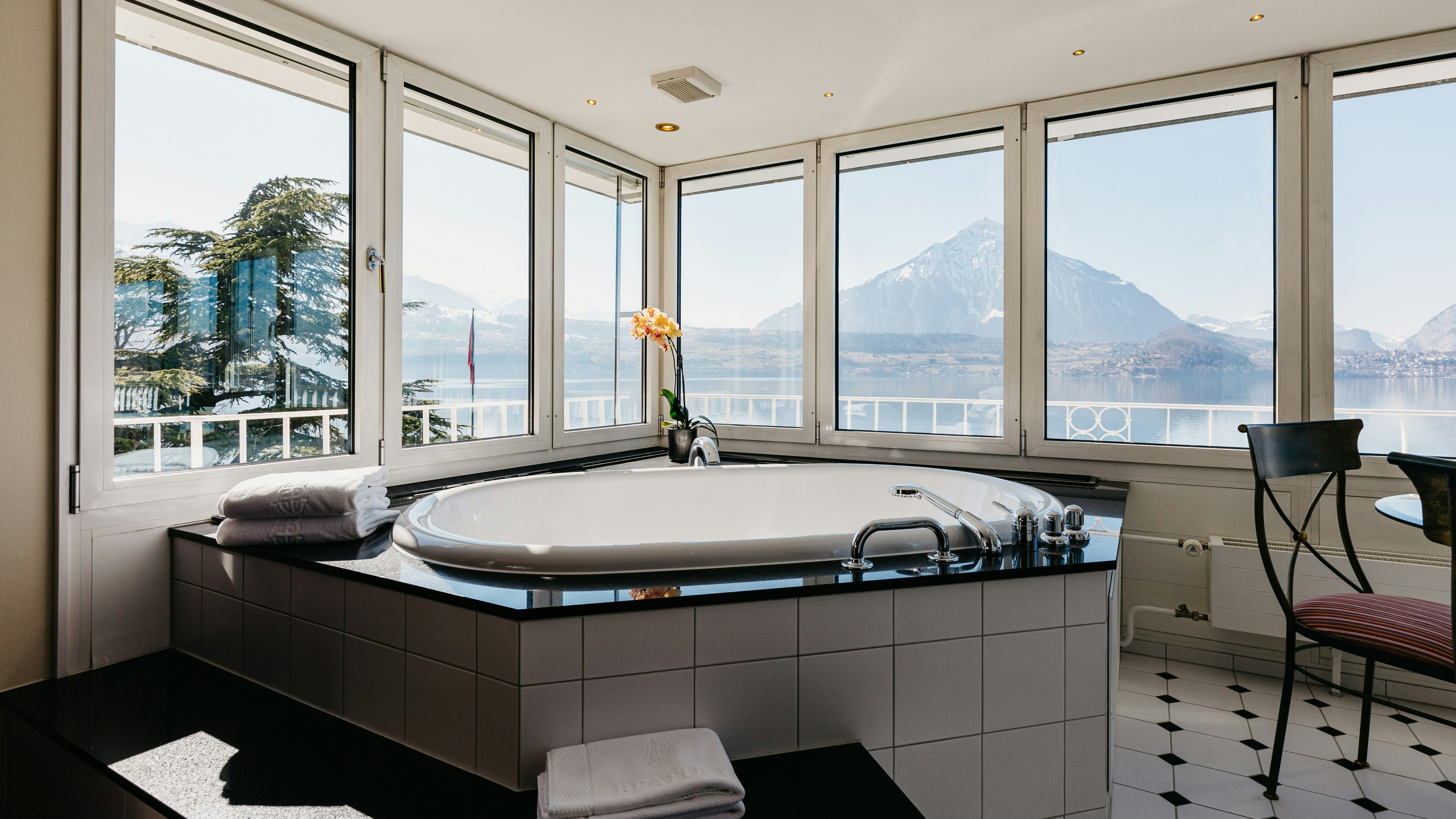 ERMITAGE Suite in the Hotel BEATUS Whirlpool tub surrounded by panoramic windows with a view of the mountains