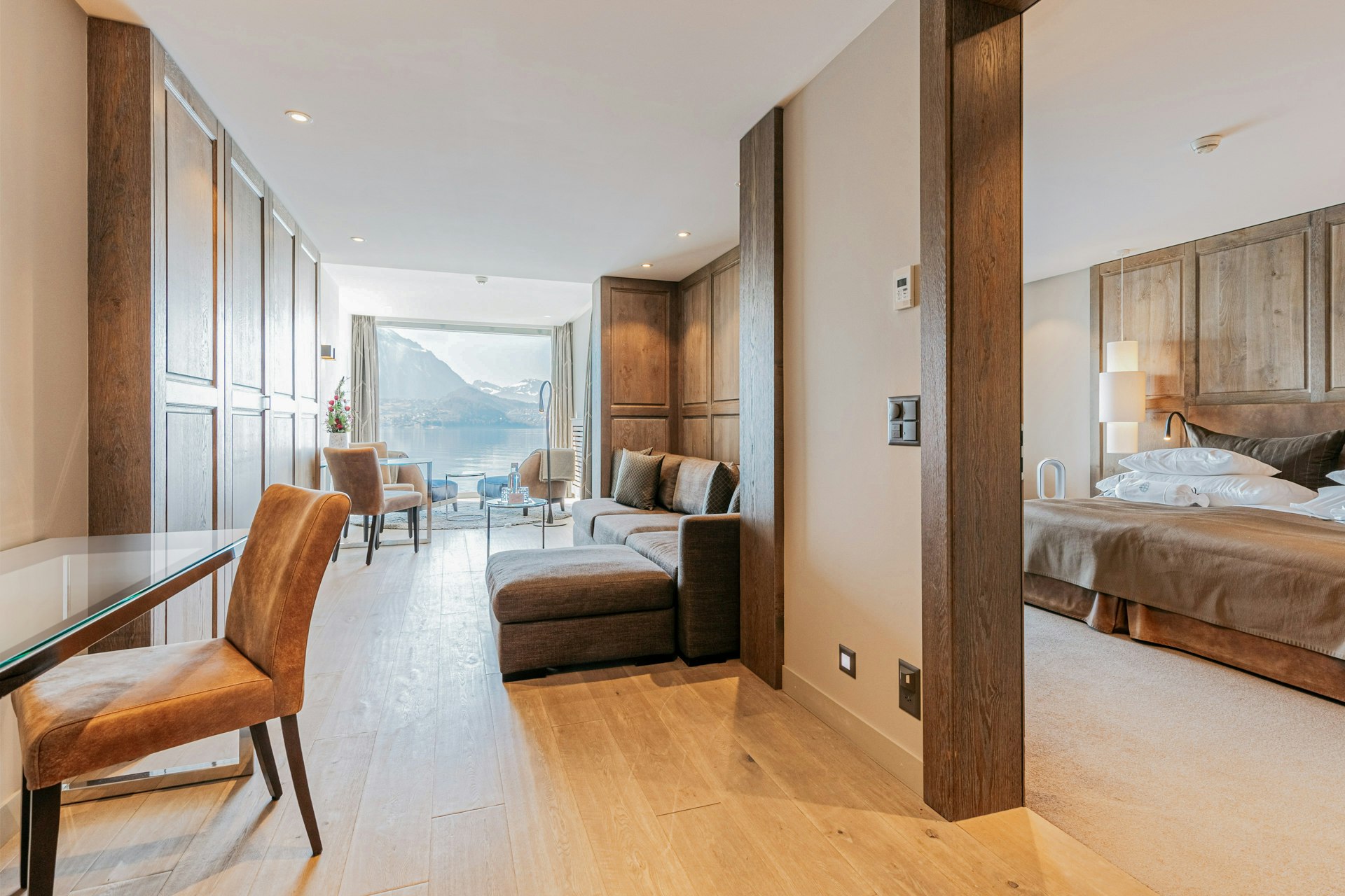 couloir avec armoire murale et salon, à droite une chambre à coucher