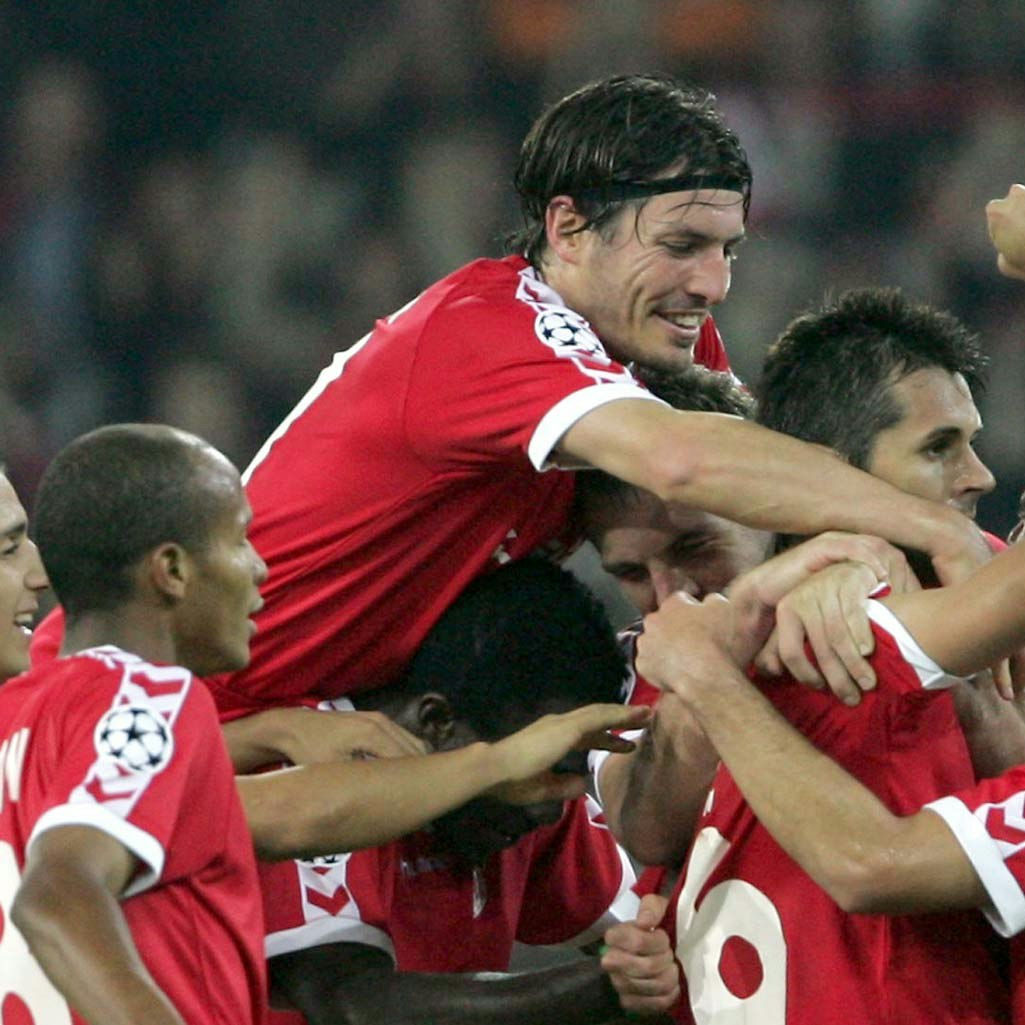 Joueurs du FC Thun Cinq joueurs de football en tenue rouge, l'un sautant sur l'autre qui lève le bras