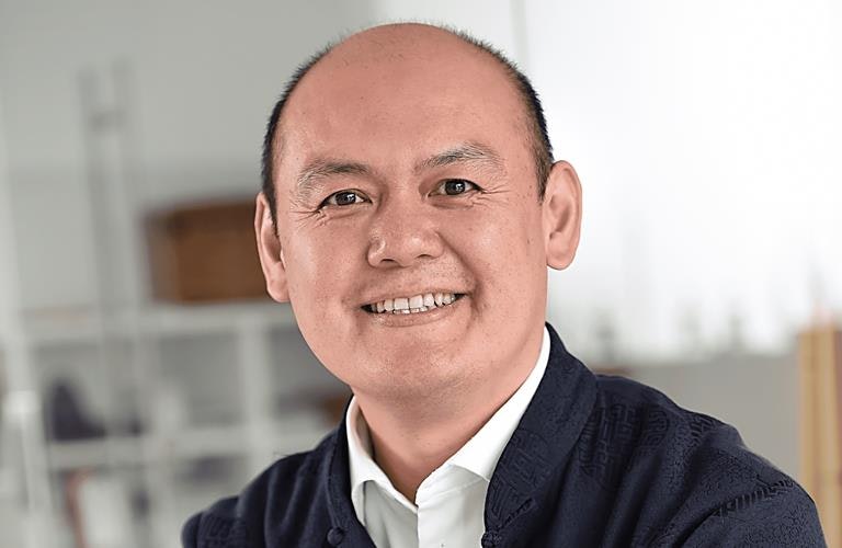 A man looks into the camera with a friendly smile