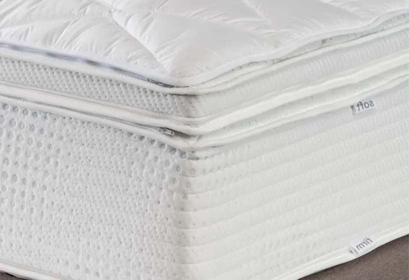 A thick white mattress with various toppers