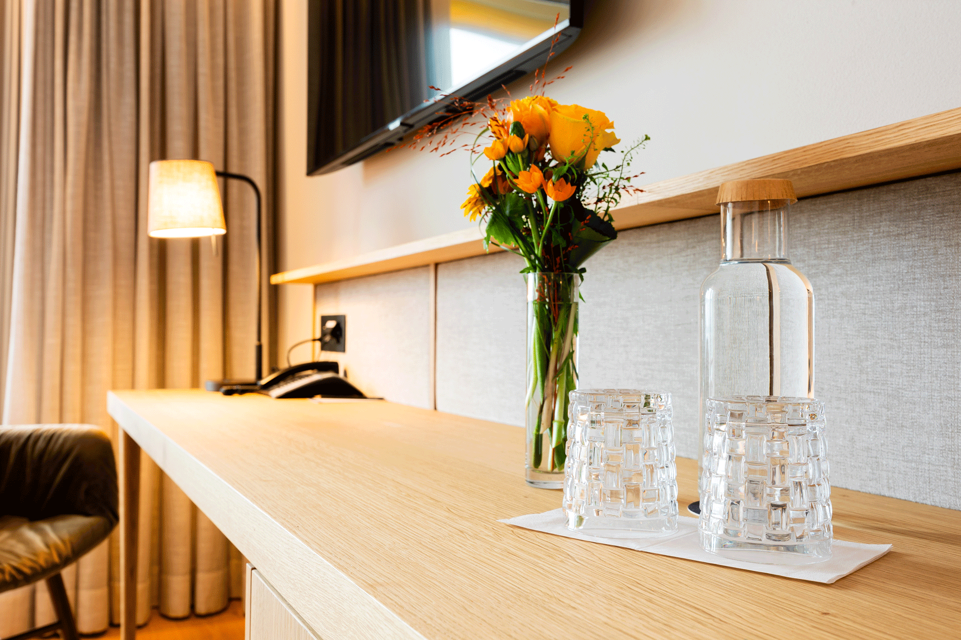 Room with table, flowers and a water carafe on it