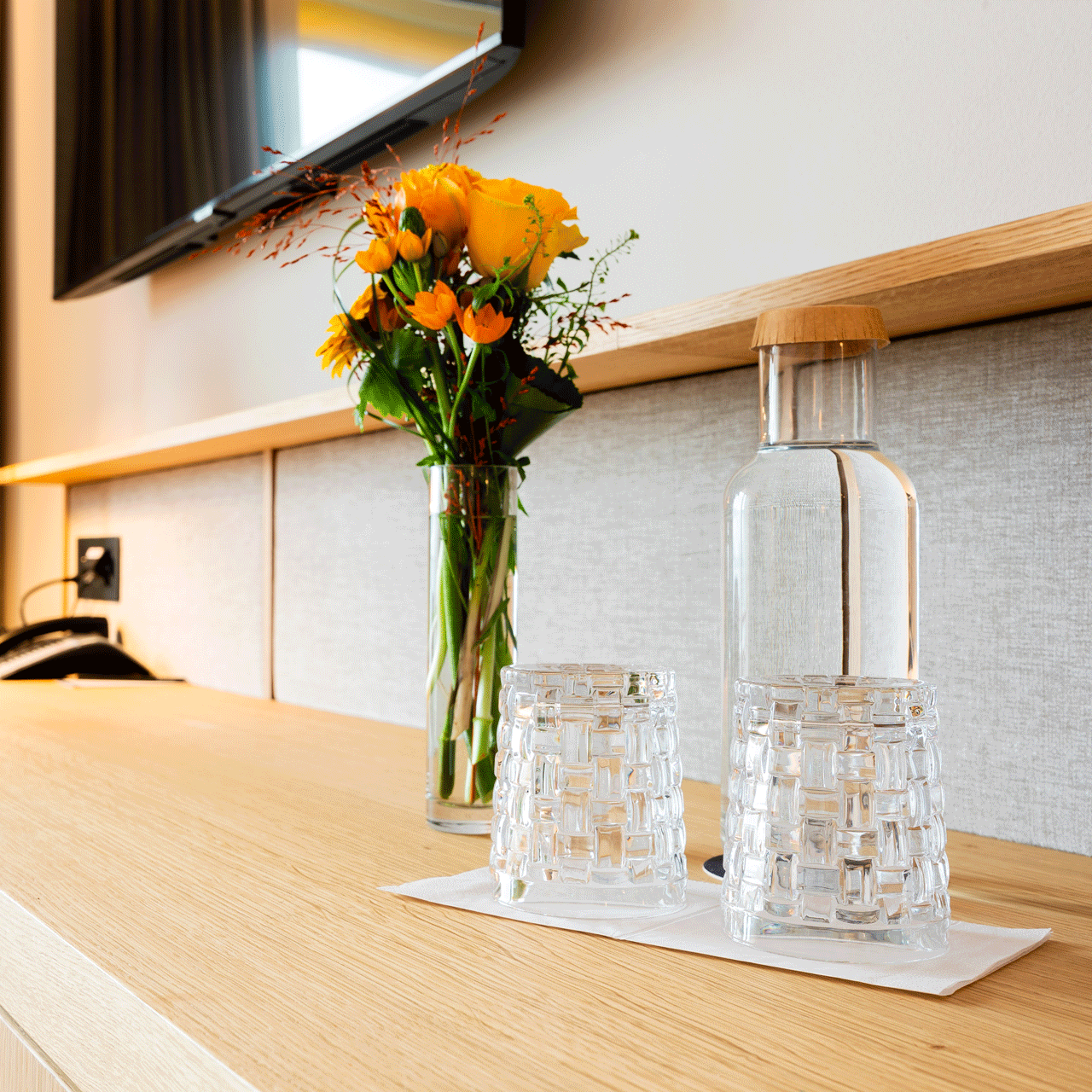 La durabilité à l'hôtel Beatus Chambre avec une table sur laquelle sont posées des fleurs et une carafe d'eau