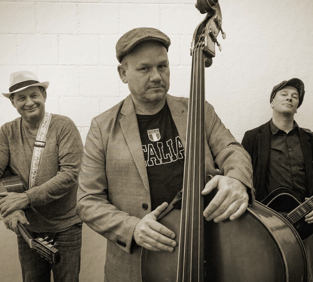 Photo dans les tons sépia d'un trio de musiciens, au centre au premier plan le contrebassiste à l'air grave