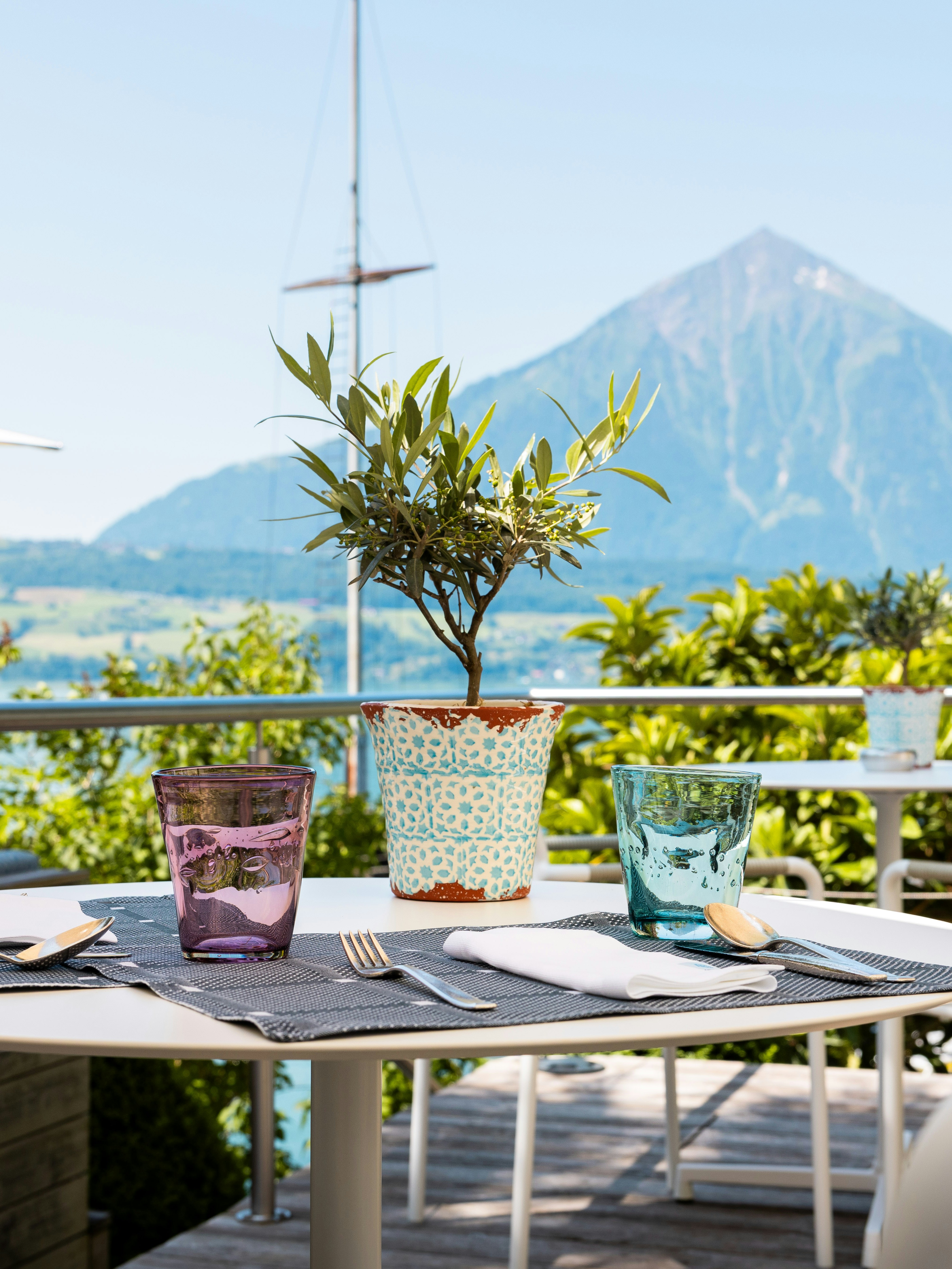 Café Le Palmier Terrace BEATUS Close-up of a set table with Mount Niesen in the background.