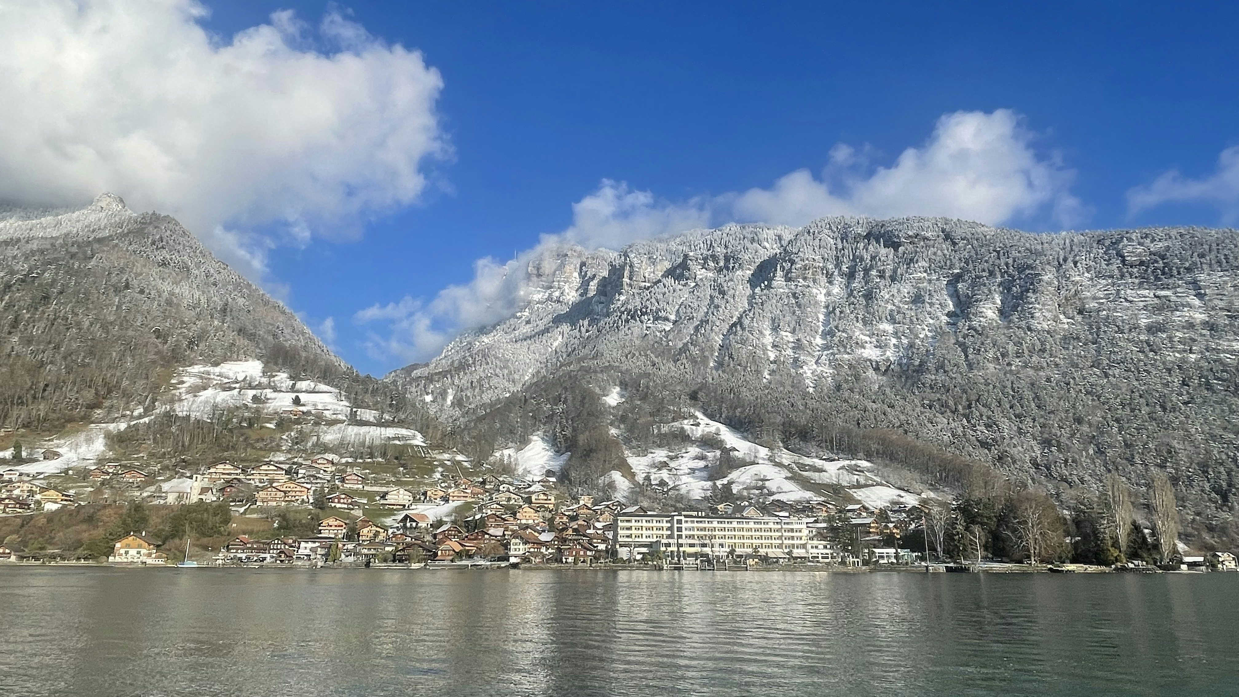 BEATUS im Winter Blick vom Thunersee Richtung Hotel BEATUS mit schneebedeckter Bergkette im Hintergrund