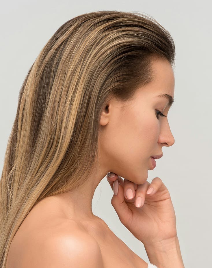 side profile of woman with her hand under her chin