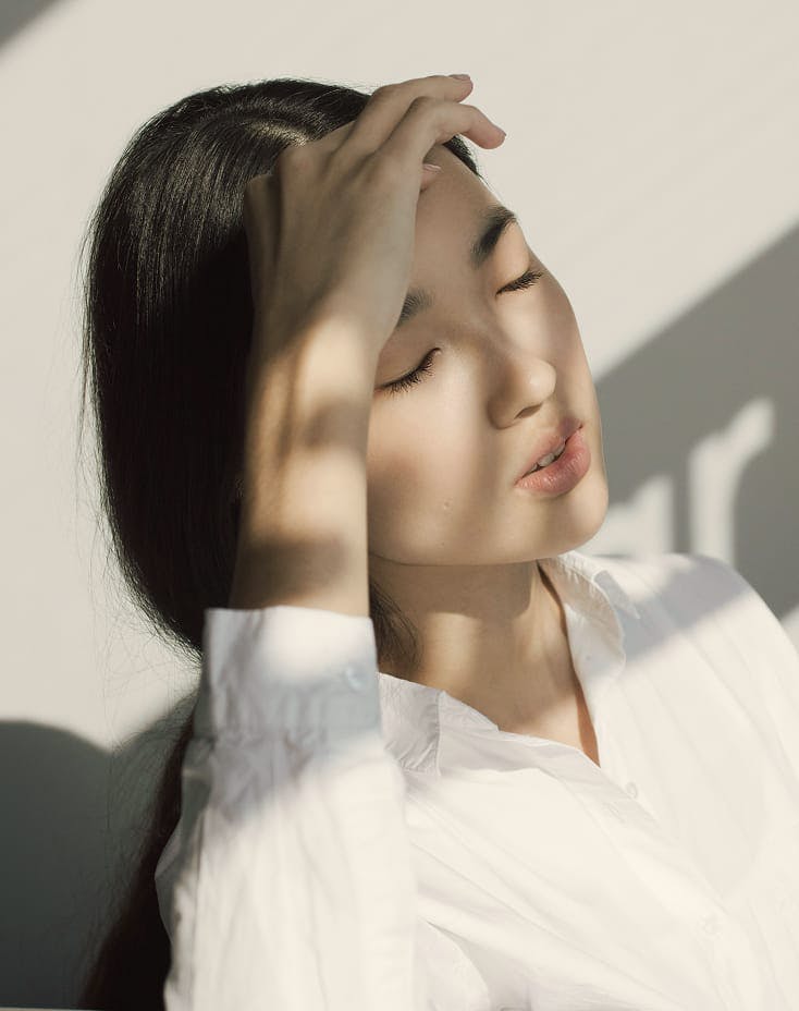 woman covering her face with her hand from the sun