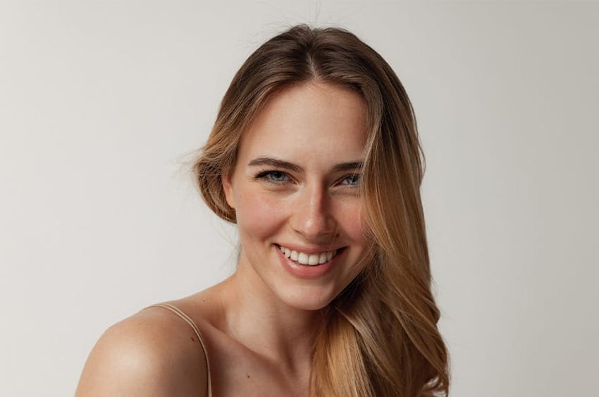 woman with hair onto one side and smiling