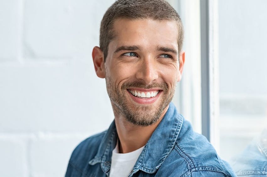 man smiling wearing jean colored jacket