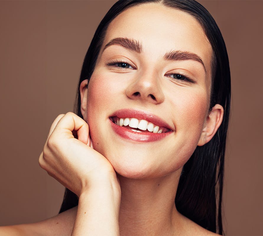 woman smiling with her chin on her hand