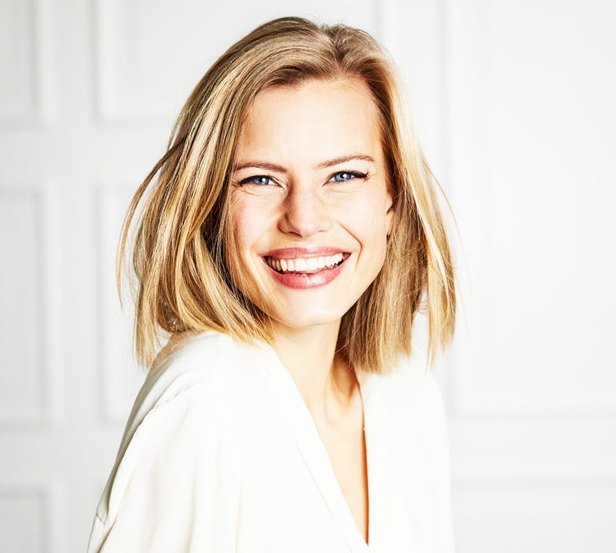 woman with blonde hair in white shirt smiling
