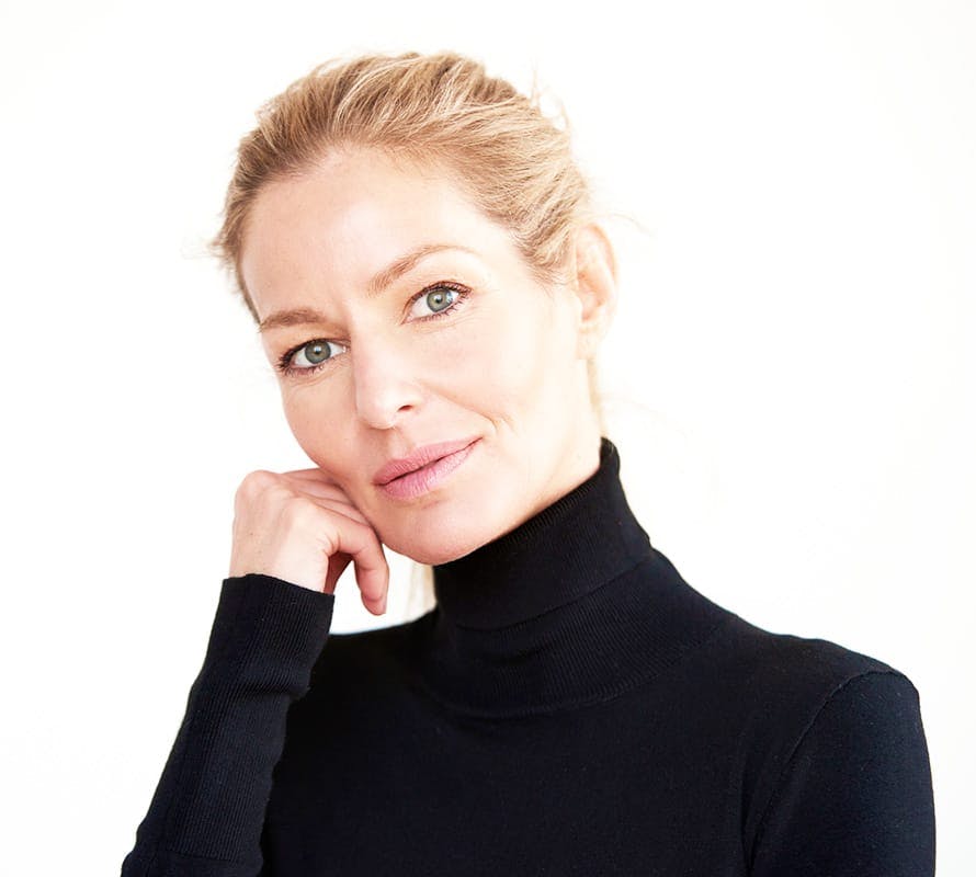woman in black turtleneck resting her head on her fist