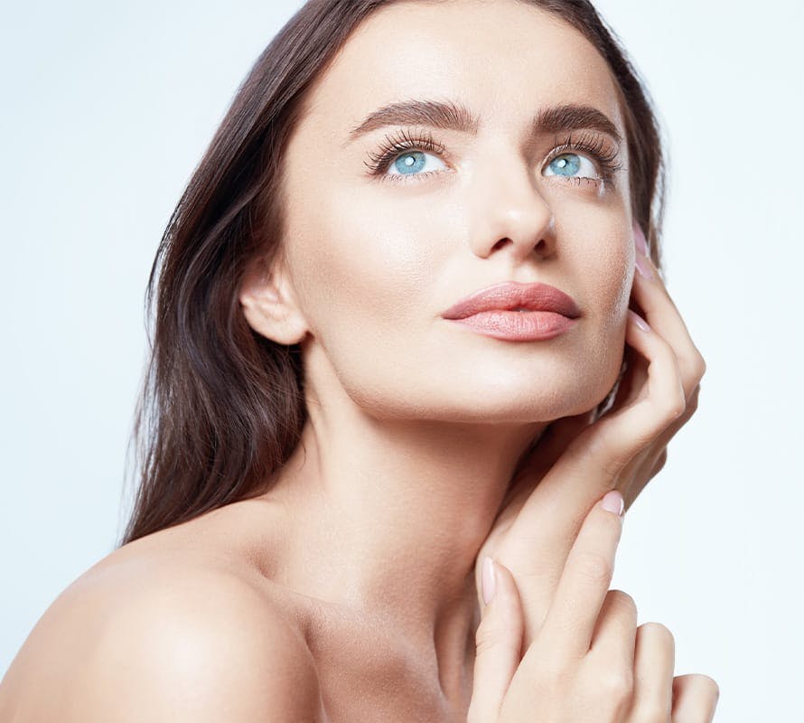 woman with her hand on her face looking upwards