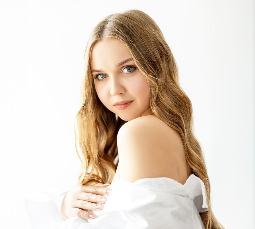 woman wearing a white off the shoulder shirt and looking forward