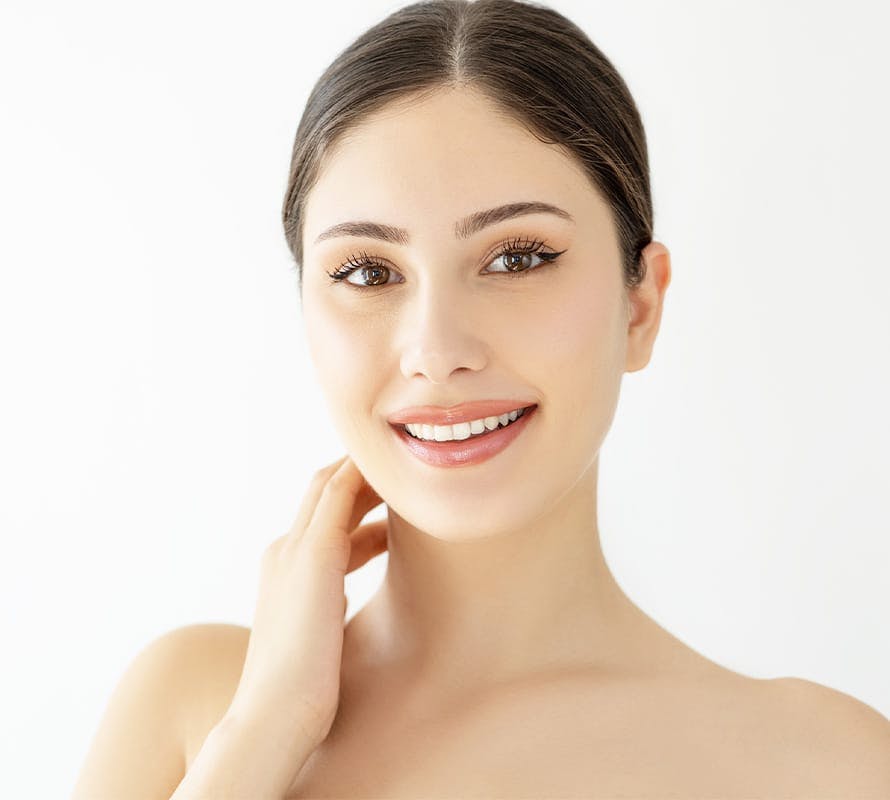 woman smiling with hand on her neck
