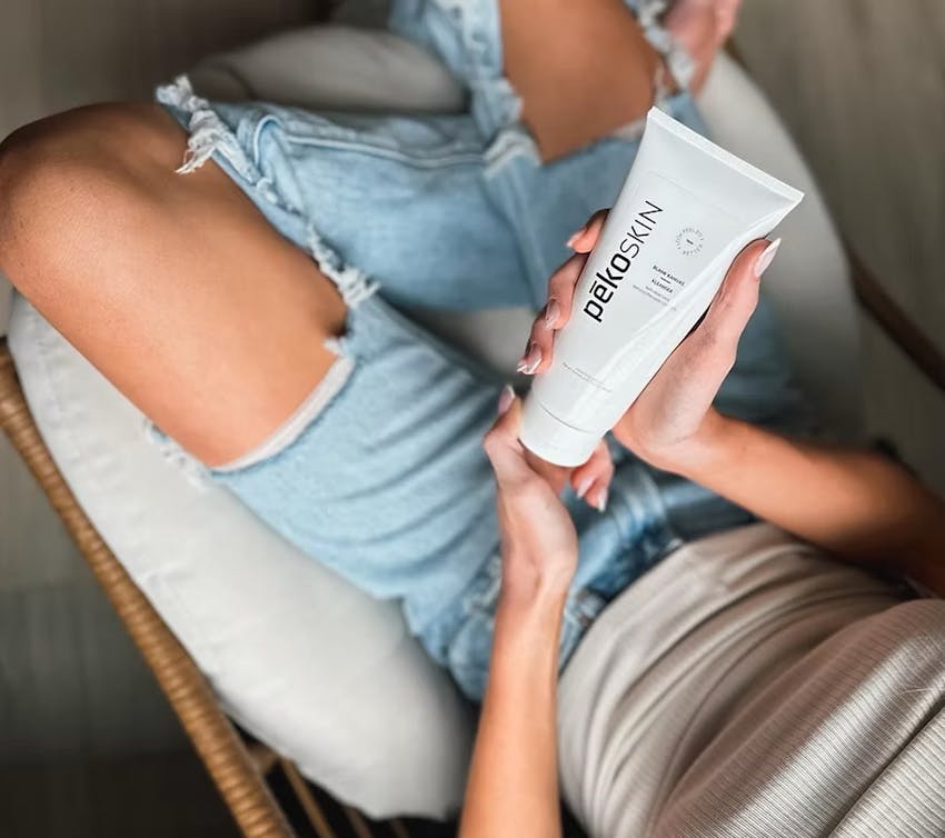 woman touching cheek looking into a mirror