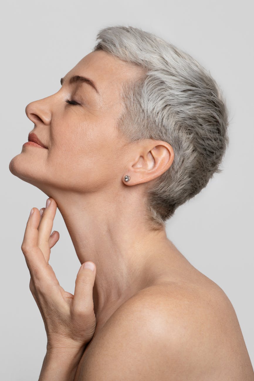 beautiful middle-aged woman touching her neck
