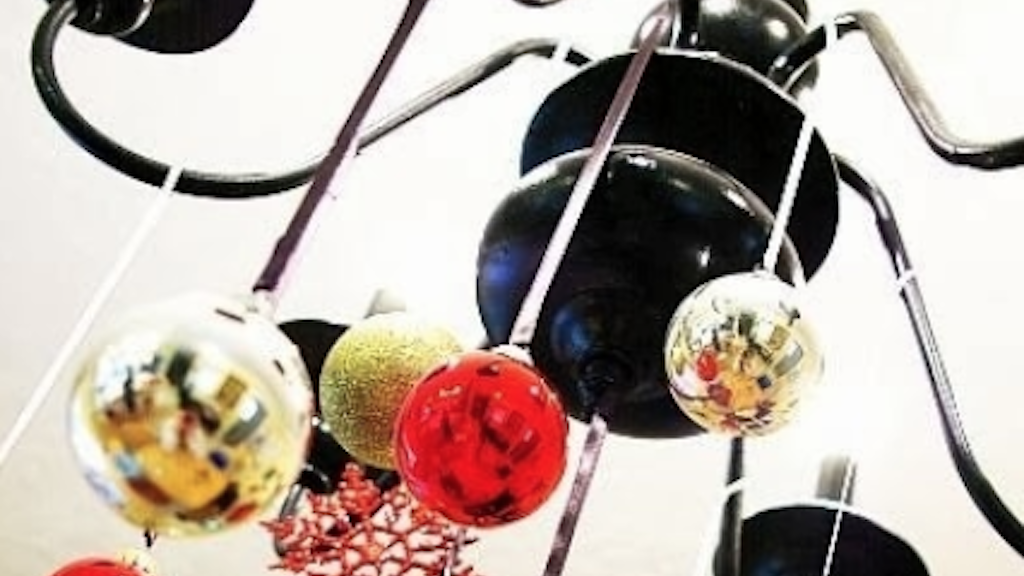 Using ribbons and tree ornaments to decorate a chandelier