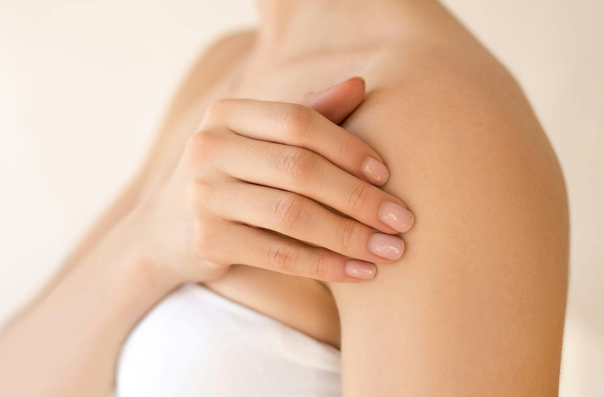 Woman rubbing her shoulder