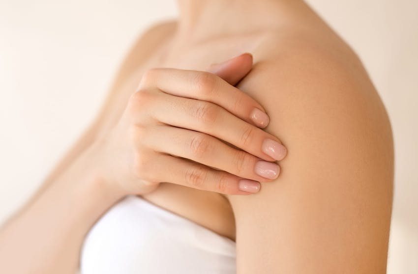 Woman rubbing her shoulder