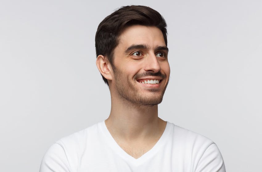 black haired man smiling in a white tshirt